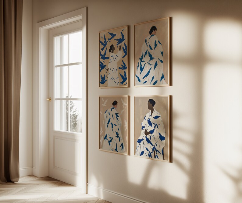 May include: Four framed art prints featuring abstract figures in white robes adorned with blue leaf-like patterns. The artwork is set against a beige background, with wooden frames. The prints are displayed on a white wall near a door.