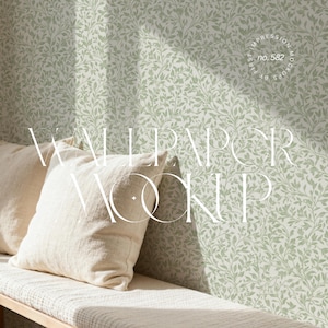 Puede incluir: Una maqueta con papel pintado verde claro con un delicado estampado de hojas. Dos almohadas color crema descansan sobre un banco de madera. Las palabras "Wallpaper Mockup" se muestran en una fuente estilizada.