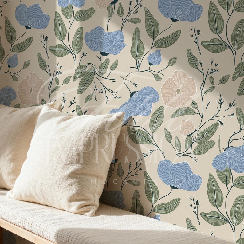 May include: A cream-colored bench with two off-white pillows in front of a floral wallpaper. The wallpaper features blue and pink flowers with green leaves and stems against a cream background.