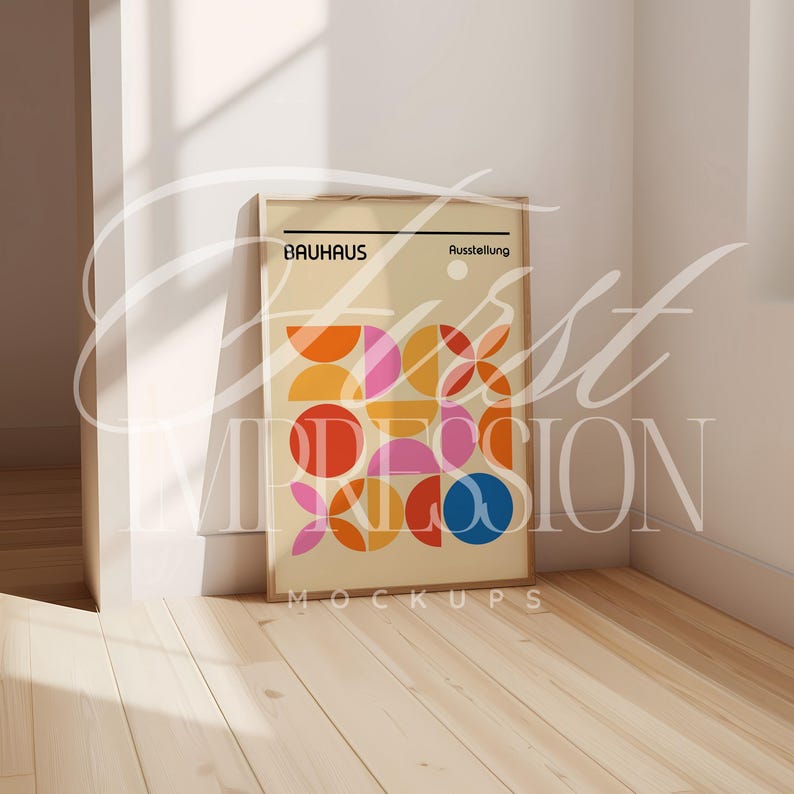 May include: A framed poster with a geometric design in shades of yellow, orange, red, pink, and blue. The poster has the text "Bauhaus Ausstellung" at the top and "MOCKUPS" at the bottom.