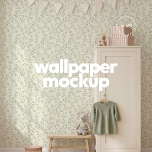 Op de afbeelding: Een kamer-mockup met lichtgroen behang met een bladpatroon. Een houten bankje houdt een stoffen muis-speelgoed vast. Een groene trui hangt aan een houten kleerhanger. De tekst "wallpaper mockup" wordt weergegeven.