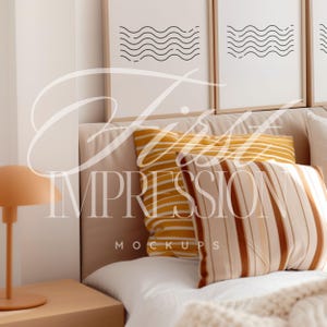 May include: A white bed with a beige headboard and a white blanket. There are two pillows on the bed, one yellow with white stripes and one brown with white stripes. There is a lamp on a wooden nightstand next to the bed.