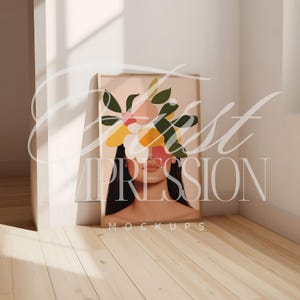 May include: A framed print of a woman's face with colorful flowers covering her eyes. The background is a light pink color. The frame is a light wood color.