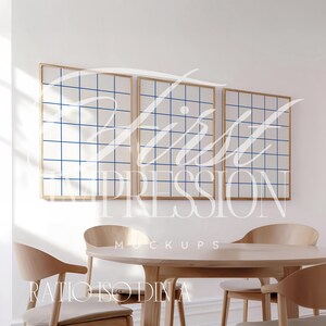 May include: Three framed grid pattern prints with a blue and white design hang on a white wall above a wooden table with four chairs. The text "First Impression Mockups" is printed below the frames.