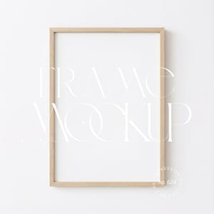May include: A rectangular wooden picture frame with a white interior, set against a white background. The frame has a light brown color. The words "FRAME MOCKUP" are displayed in a white, stylized font across the frame. The text "IMPRESSION MOCKUPS BY PERS no. 624" is in the lower right corner.