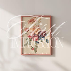 May include: A pink framed print of a watercolor painting of a bouquet of flowers. The flowers are pink, yellow, blue, and purple. The frame has the text "MOCKUPS" at the bottom.