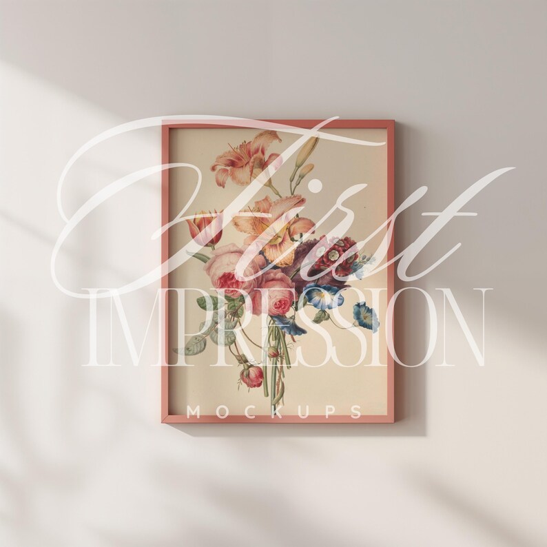 May include: A pink framed print of a watercolor painting of a bouquet of flowers. The flowers are pink, yellow, blue, and purple. The frame has the text "MOCKUPS" at the bottom.