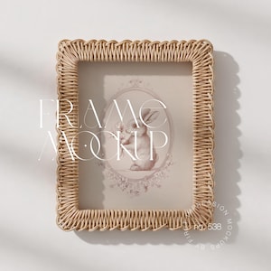 Può includere: Una cornice rettangolare intrecciata con un bordo smerlato. La cornice contiene una stampa di un coniglio che tiene dei fiori all'interno di un bordo ovale. Il testo "FRAME MOCKUP" è sovrapposto all'immagine.