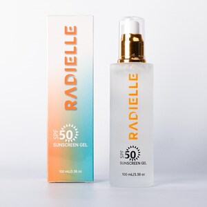 May include: A bottle and box of Radielle SPF 50 sunscreen gel. The bottle is frosted with a gold pump and the box has a gradient of orange and blue. Both the bottle and box have the Radielle logo and product information.