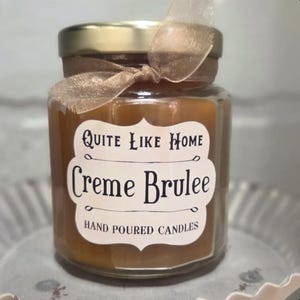 Creme Brulee scented 6.5 oz. jar candle with gold lid, and organza ribbon. Dessert, caramel, sweet, sugar, sugary, rich, spices, vanilla