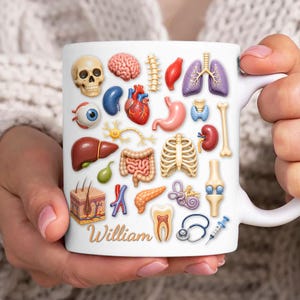 May include: White ceramic mug featuring colorful illustrations of human anatomy, including a brain, heart, lungs, and bones. The name "William" is printed in gold script. A medical-themed gift.