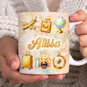 May include: A white ceramic mug featuring a world map design with gold travel-themed illustrations, including a plane, passport, globe, suitcase, camera, and compass. The name "Alissa" is written in gold script.