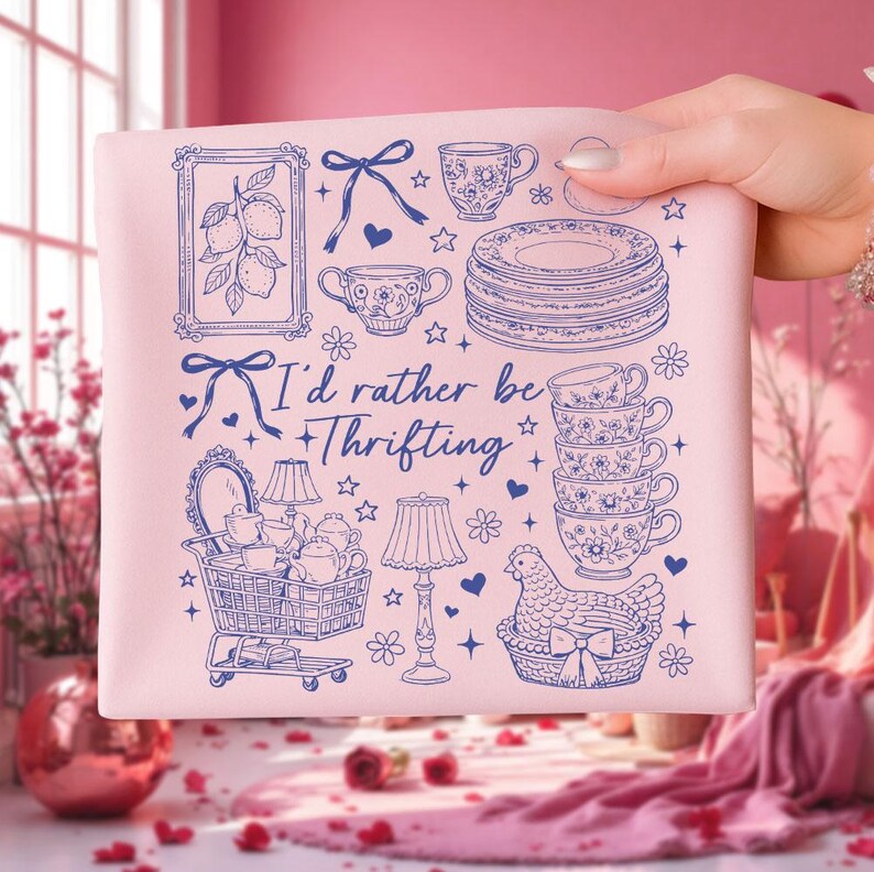 May include: A pink square fabric with a blue illustration of various vintage items, including teacups, plates, and a shopping cart. The text "I'd rather be thrifting" is also featured in blue.