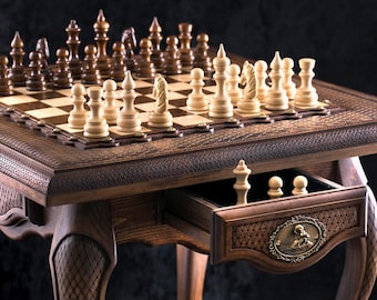 Peut inclure: Un jeu d'échecs en bois détaillé avec des pièces sculptées de manière complexe et un échiquier assorti. Les pièces marron foncé et claires sont disposées sur un échiquier à carreaux. Un tiroir contient des pièces supplémentaires. La table a des pieds ornés.