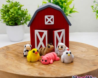 May include: A red barn with a gray roof and white door accents, surrounded by miniature farm animal figurines. The figurines include a cow, chick, pig, horse, sheep, and chicken. The figurines are on a wooden surface.