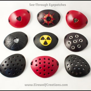 An assortment of see-through handmade leather eye patches in various designs, including hearts, compass rose, radiation hazard, grommets, and perforated. All but the grommets are backed with translucent fabric, either black, silver, or gold colored.