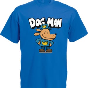 May include: A royal blue t-shirt featuring the words "DOG MAN" in white block letters above a cartoon dog character. The dog is wearing a blue uniform and hat with a gold badge.