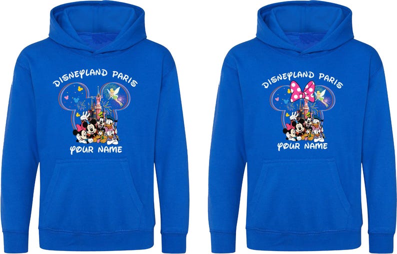 May include: Two blue hoodies with the text "Disneyland Paris" above a Mickey Mouse head design. The design includes Disney characters and a castle. The text "YOUR NAME" is below the design. One hoodie has a pink bow.