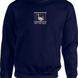 May include: A navy blue sweatshirt with a white graphic of a duck in a cage and the text "GOT TOO SILLY".