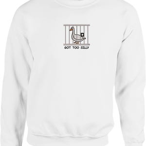 May include: White long-sleeve sweatshirt with a cartoon image of a duck in a cage and the text "GOT TOO SILLY".