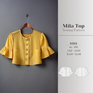 以下が含まれることがあります： 黄色のMila Topのソーイングパターン。トップスは短いフリル袖で、グリーンのボタンでフロントを留めます。パターンにはXSから8XLまでのサイズが含まれています。