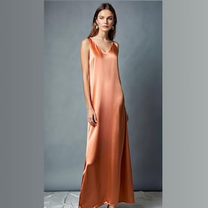 May include: A long, sleeveless, peach-colored satin dress with a V-neckline.