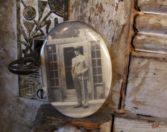 vintage celluloid photo pocket mirror circa 1920s man in front of apartment hotel entrance deco era sepia tone photograph