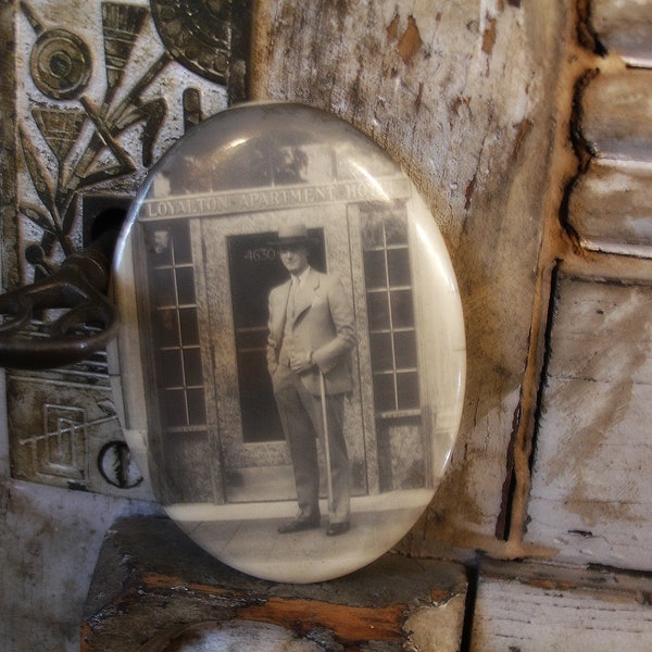 vintage celluloid photo pocket mirror circa 1920s man in front of apartment hotel entrance deco era sepia tone photograph