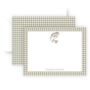 May include: Stationery set featuring a white card with a watercolor illustration of a leaping fish. The card has a light green gingham border and the name "THOMAS SUTTON" printed at the bottom. An envelope is included.