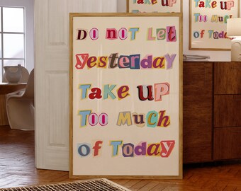 May include: A framed print with the text "Do not let yesterday take up too much of today" in colorful, cut-out letters on a cream background.