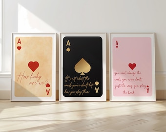 May include: Three printable wall art prints featuring an ace of spades playing card with inspirational quotes. The first print has a beige background with the quote "How lucky are we?" The second print has a black background with the quote "It's not about the cards you're dealt but how you play them." The third print has a pink background with the quote "You can't change the cards you were dealt, just the way you play the hand."