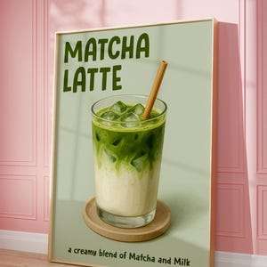 May include: Framed print of a matcha latte. The image depicts a glass of layered matcha and milk with ice cubes and a wooden straw, on a wooden coaster. The text "Matcha Latte" is at the top, with "a creamy blend of Matcha and Milk" at the bottom.