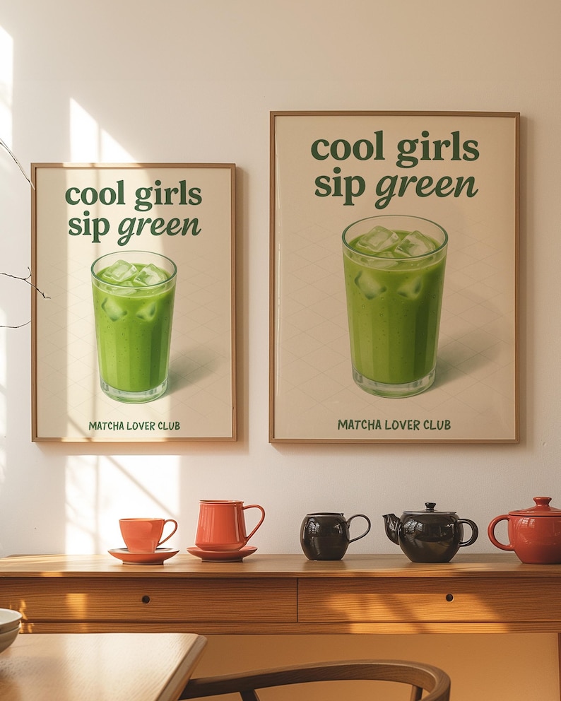 May include: Two framed posters with the text "cool girls sip green" and a green drink with ice. Below the text is "MATCHA LOVER CLUB". Below the posters are orange teacups and teapots.