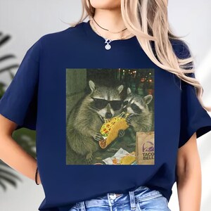 A raccoon wearing sunglasses is eating a taco, as depicted in the image.