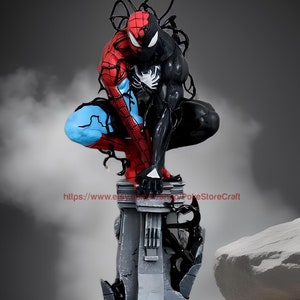 May include: A black and red Spider-Man figure with a black Venom symbiote, standing on a gray, broken, stone base. The figure is in a crouching pose, with its arms raised and its fists clenched.