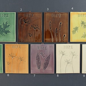 May include: Nine ceramic tiles with the word "HOPE" and a different nature-inspired design on each. The tiles are in various colors, including green, brown, yellow, orange, purple, and white.