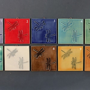 May include: Ten ceramic tiles with dragonfly designs in various colors, including purple, red, blue, green, white, brown, yellow, and orange. Each tile has a number from 1 to 10.