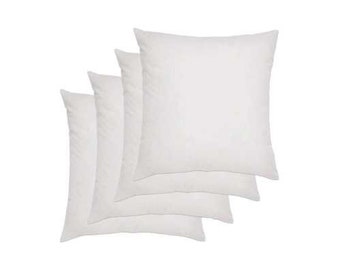 May include: Four white pillow inserts, stacked on top of each other. The pillow inserts are square shaped and made of a soft, white fabric.