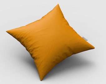 May include: A square, orange decorative pillow with a diamond shape. The pillow is a solid color and has a tag on one corner. The pillow is made of a soft material and is likely used for home decor.