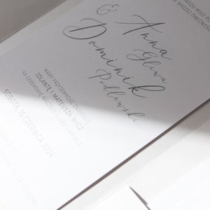 May include: A white wedding invitation with the text "BĘDZIE NAM BARDZO MIŁO PO "TAK" W WASZEJ OBECNOŚCI" and "& Anna Gliwa Dominik Podlewski" in cursive script. The invitation also includes the date "SOBOTA, 15 CZERWCA 2024".
