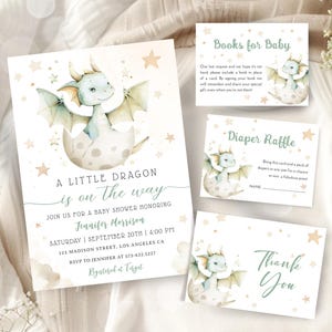 Può includere: Un invito a un baby shower con un'illustrazione di un drago verde e blu su una luna con stelle. L'invito recita "A Little Dragon is on the way" e include il nome Jennifer Morrison, la data e l'ora della festa, e l'indirizzo. L'invito include anche una nota sul registro presso Target.