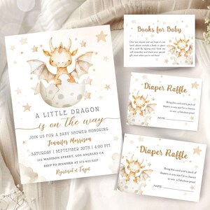 Può includere: Set di inviti per baby shower con un'illustrazione ad acquerello di un draghetto che esce da un uovo. L'invito include i dettagli dell'evento, più biglietti per libri e una lotteria di pannolini. Il design utilizza tenui tonalità beige e oro.