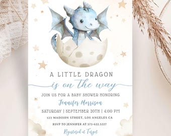 May include: A baby shower invitation with a blue watercolor dragon hatching from an egg on a moon. The text reads "A Little Dragon is on the way" and includes details for the event, including the date, time, location, and RSVP information. The invitation also states "Registered at Target".