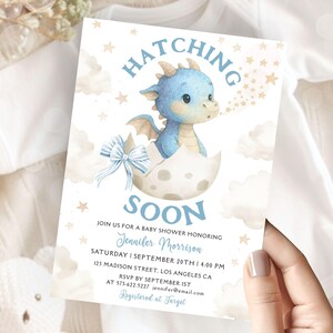 May include: Baby shower invitation featuring a blue dragon hatching from an egg, with clouds and stars. The text reads "Hatching Soon" and includes event details and RSVP information.