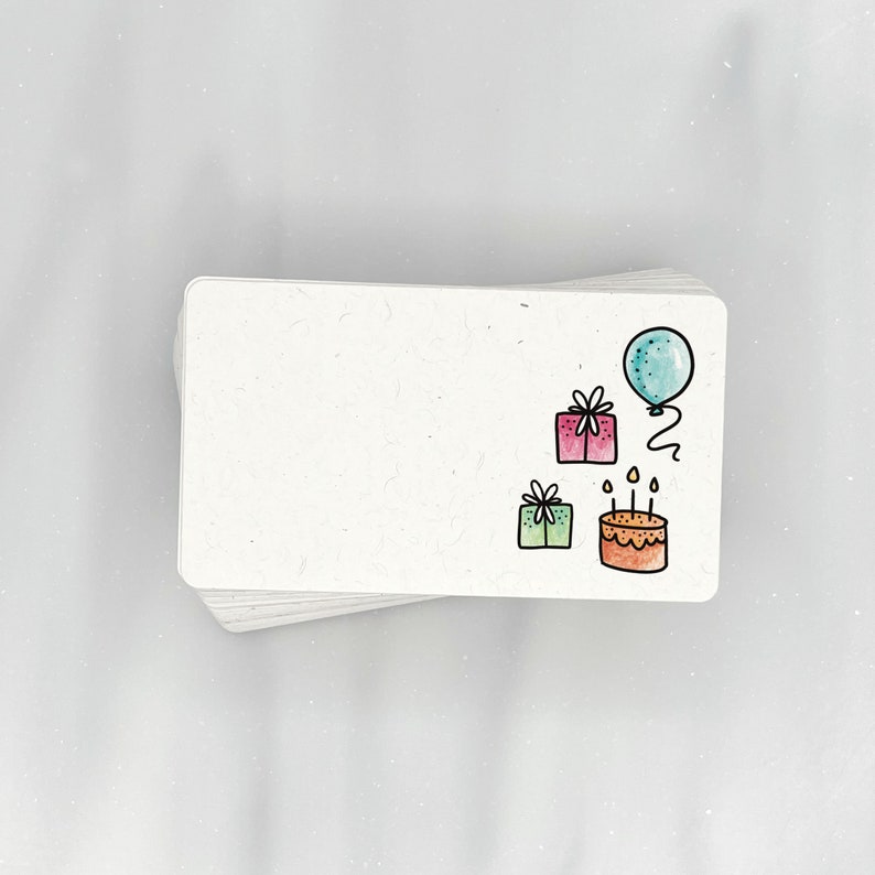 Puede incluir: Una tarjeta blanca con un tema de cumplea&ntilde;os. La tarjeta tiene un globo azul, dos regalos y un pastel de cumplea&ntilde;os con velas.