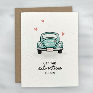 May include: A light blue car with a "Just Married" sign and a "4EVER" license plate. The car is surrounded by pink hearts. The text "Let the adventure begin" is below the car.