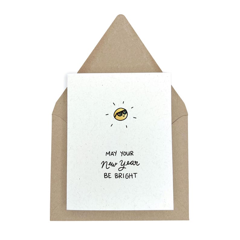 May include: A white card with a yellow sun wearing sunglasses and the text "May your New Year be bright".