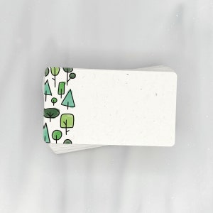 May include: A stack of blank white cards with a green and blue pattern of trees on the left edge.