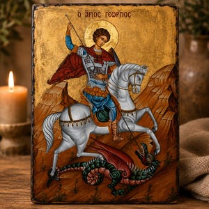 Puede incluir: Icono religioso que representa a un santo a caballo matando a un dragón. La obra de arte presenta un fondo dorado, un caballo blanco y un dragón rojo y verde. El texto "ο άγιος γεώργιος" está en la parte superior.
