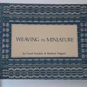 May include: A blue and white patterned book cover with the title "Weaving in Miniature" by Carol Strickler & Barbara Taggart.